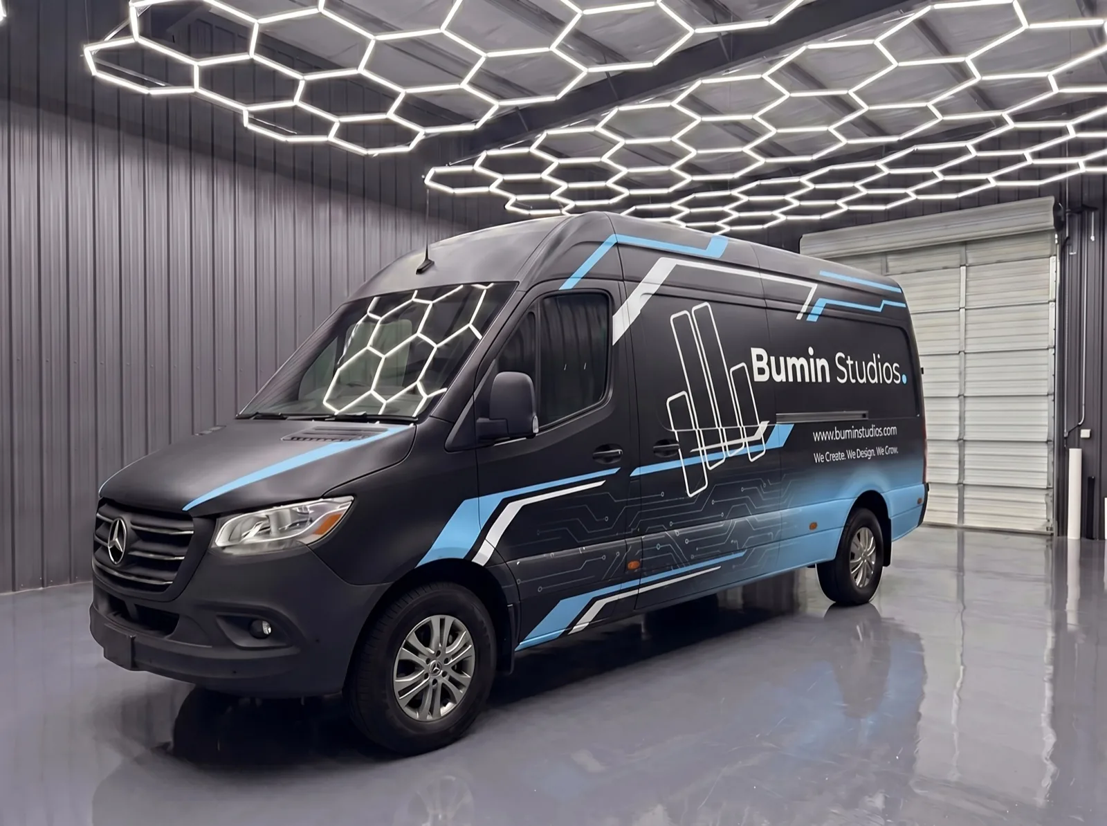 Matte black Mercedes-Benz Sprinter with a futuristic Bumin Studios commercial wrap